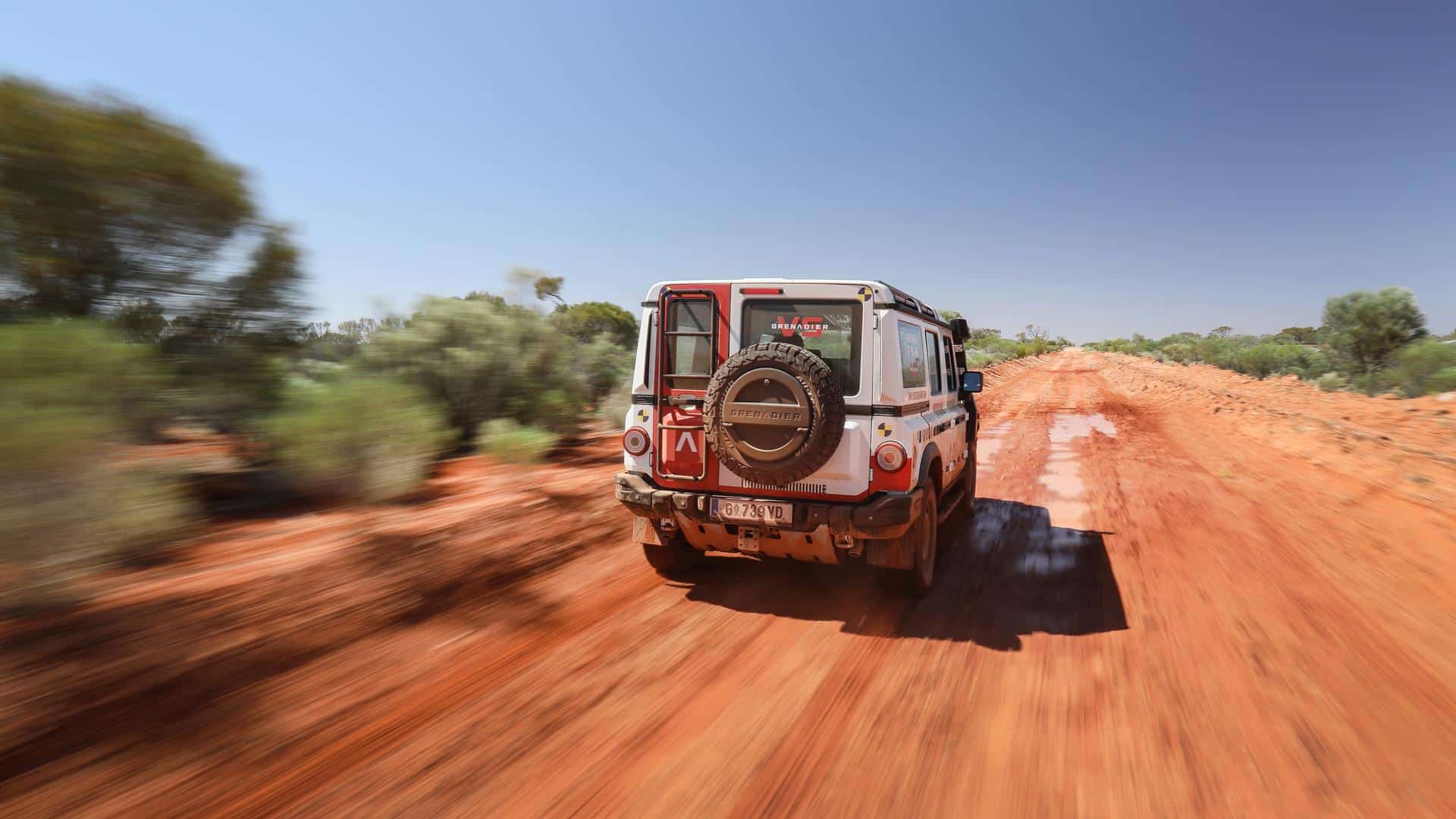 Ineos Grenadier driving on a dirt road.