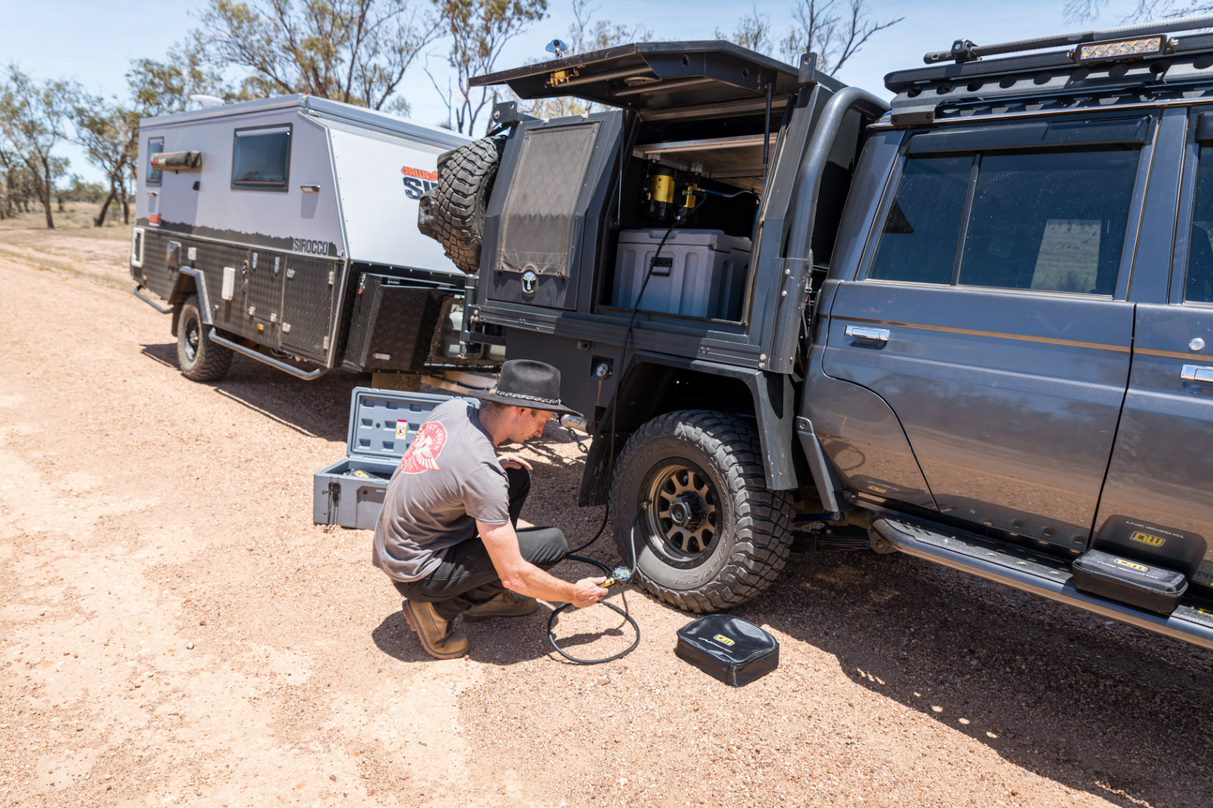 A 12V compressor pumping up a tyre in the outback