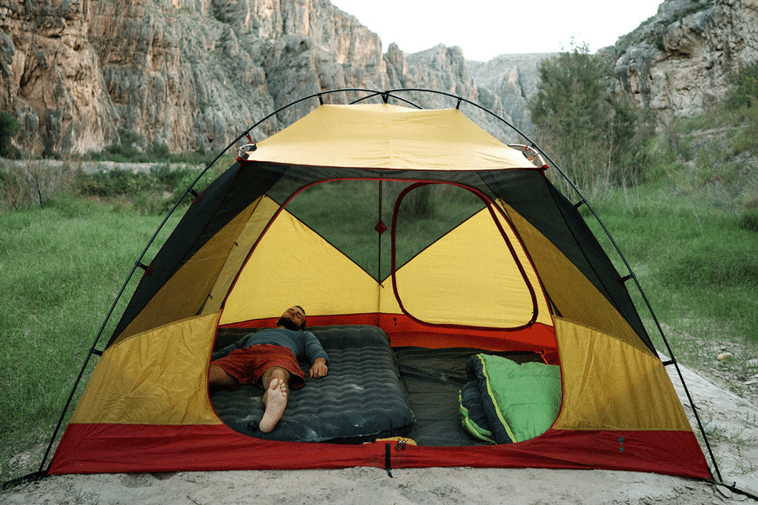 Man on mattress in tent camping