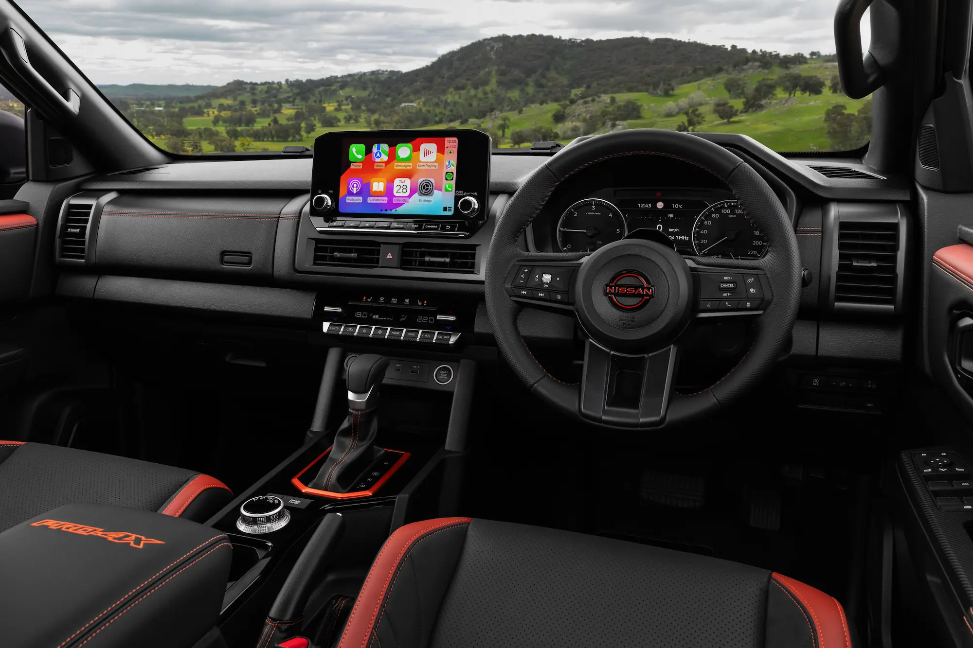 Interior dashboard layout showing infotainment screen and physical climate dials