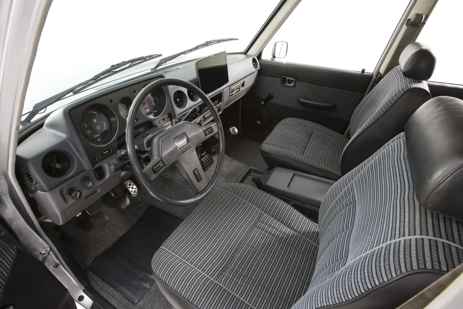 Toyota 60 Series Land Cruiser restored interior with Alpine touchscreen and original seven-seat layout